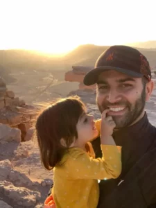 Father holding his smiling young daughter outdoors