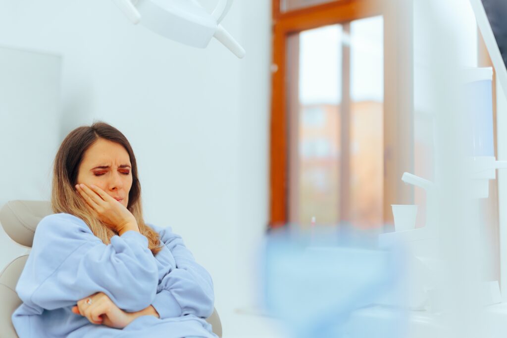 Woman holding her jaw in a dental waiting room