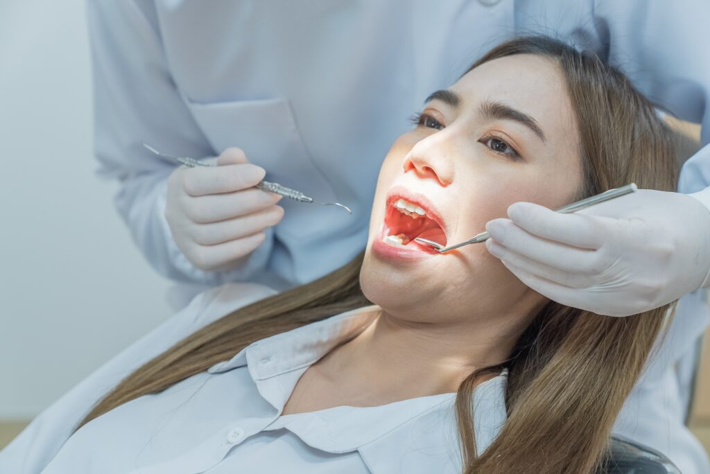 Dental professional examining a patient’s mouth