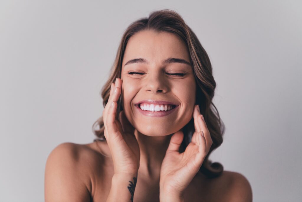 Woman smiling with her hands resting on her cheeks