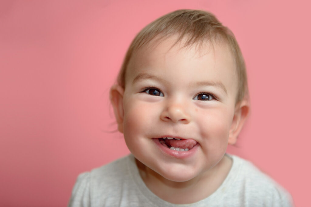 Baby smiling with their first teeth visible