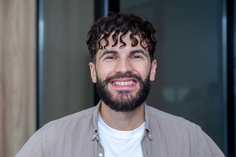 Man smiling with braces on his teeth