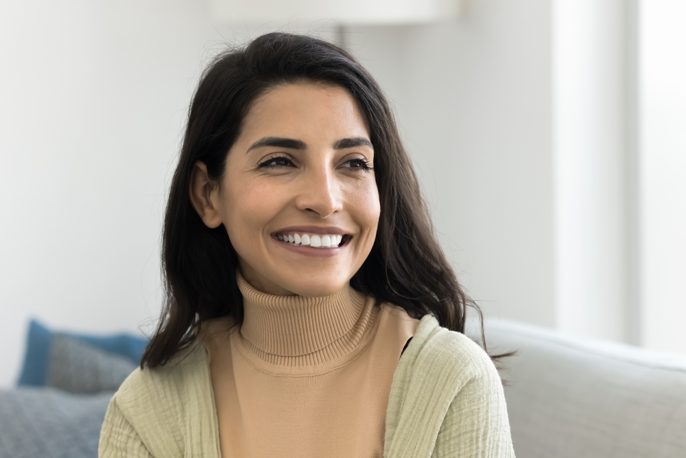 Woman smiling while seated indoors